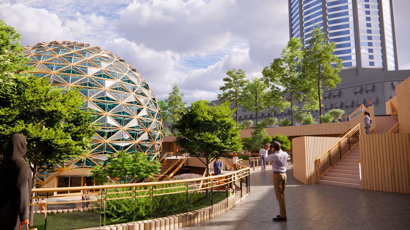 Timber boardwalk through planting toward the dome, with towers behind