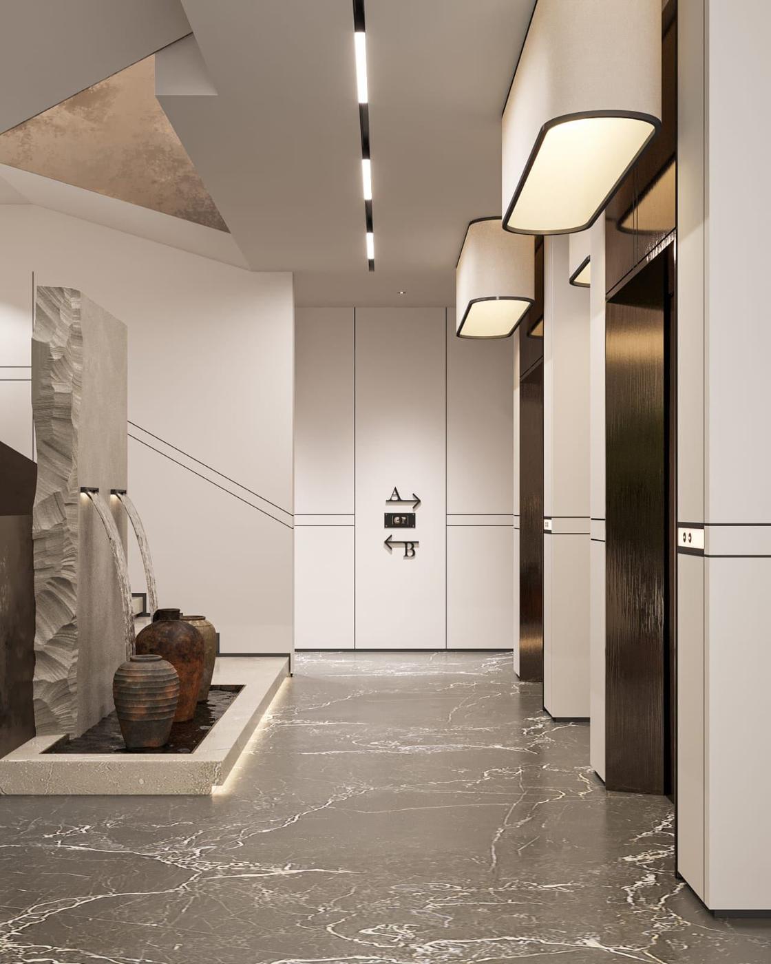 Lift lobby with marble floor and a sculpted wall fountain